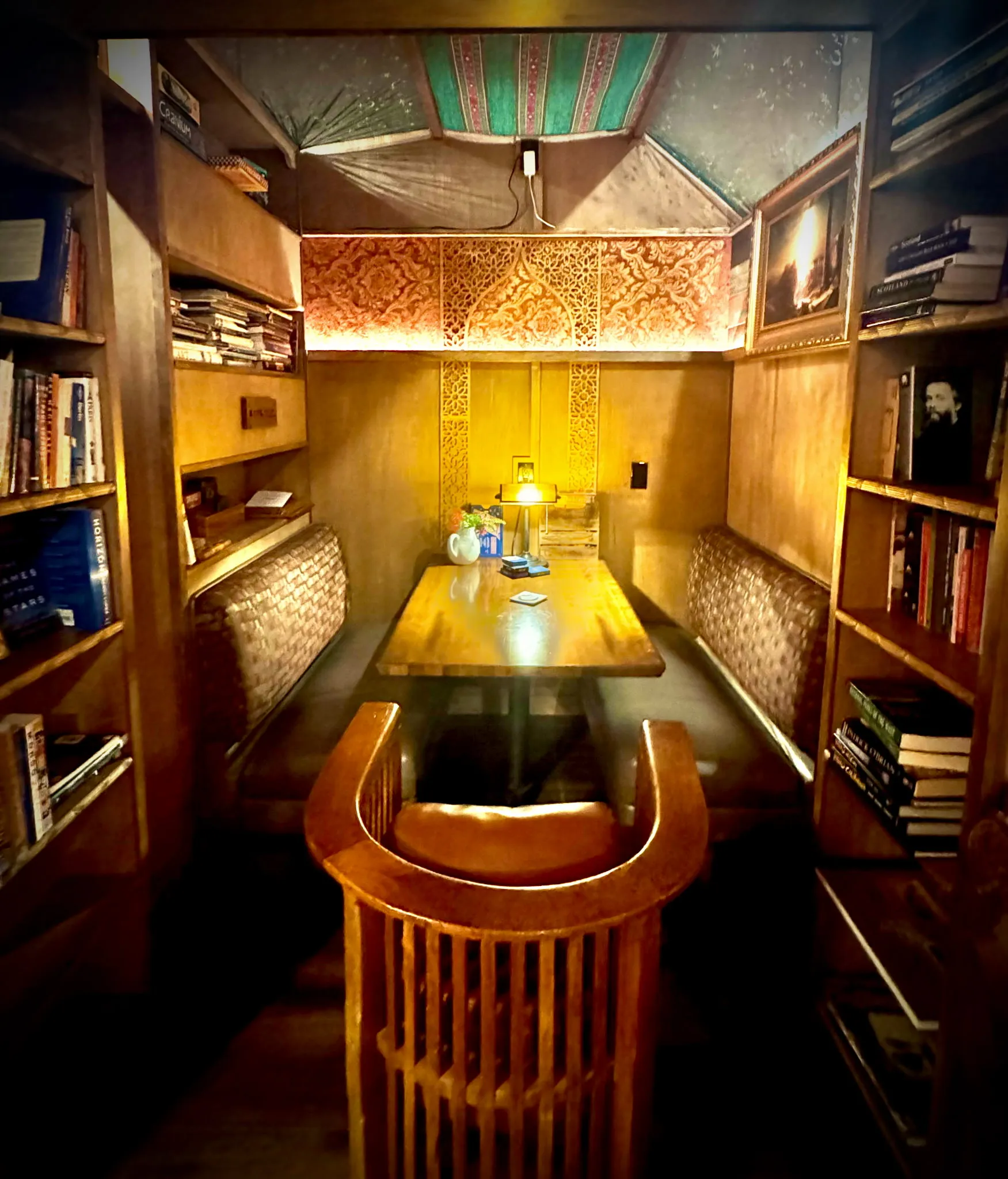 A booth nook with bookshelves and warm lighting at Our Third Space in Veneta, Oregon.